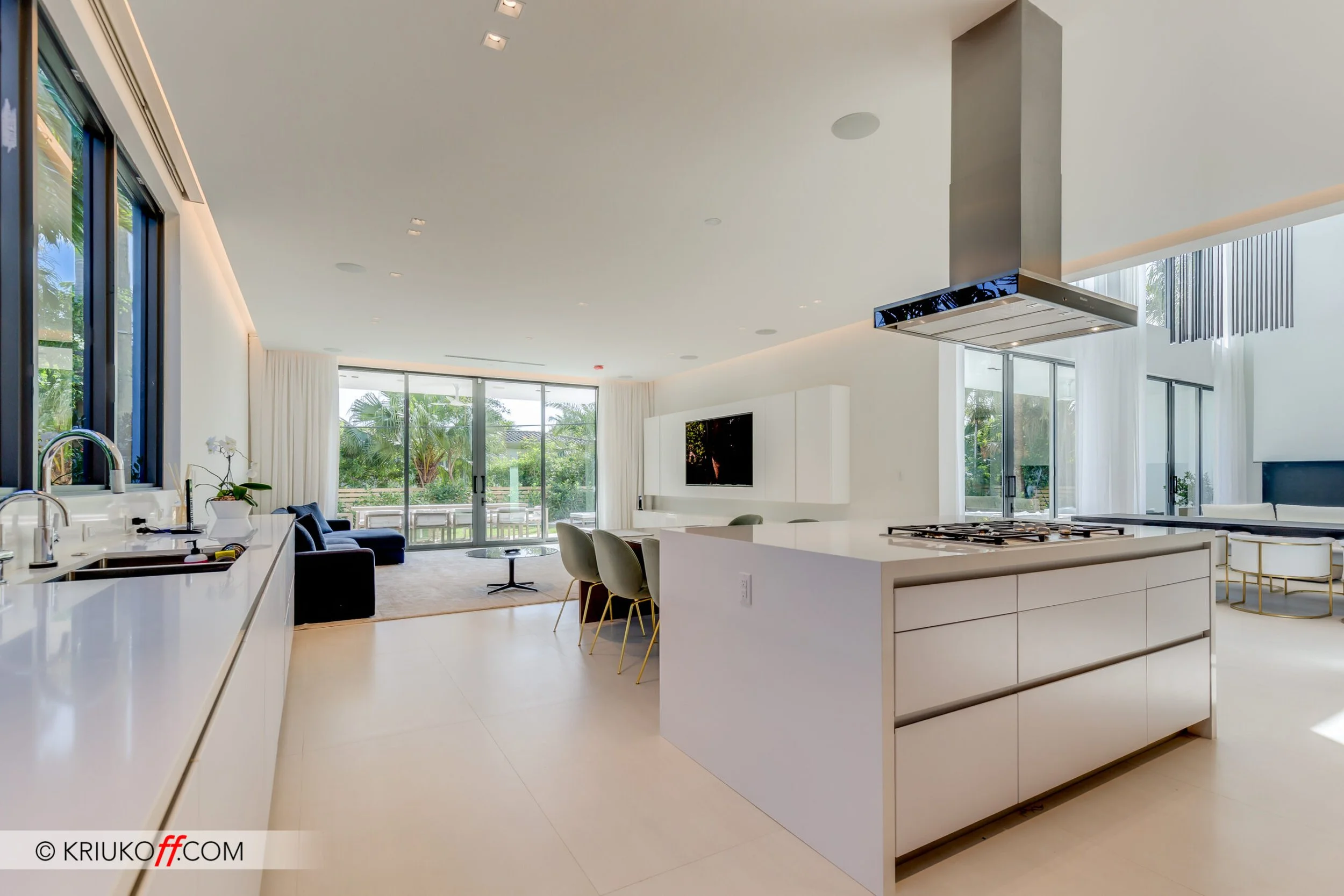 A sleek white modern kitchen from sneidero with high-end appliances and a few pops of color.