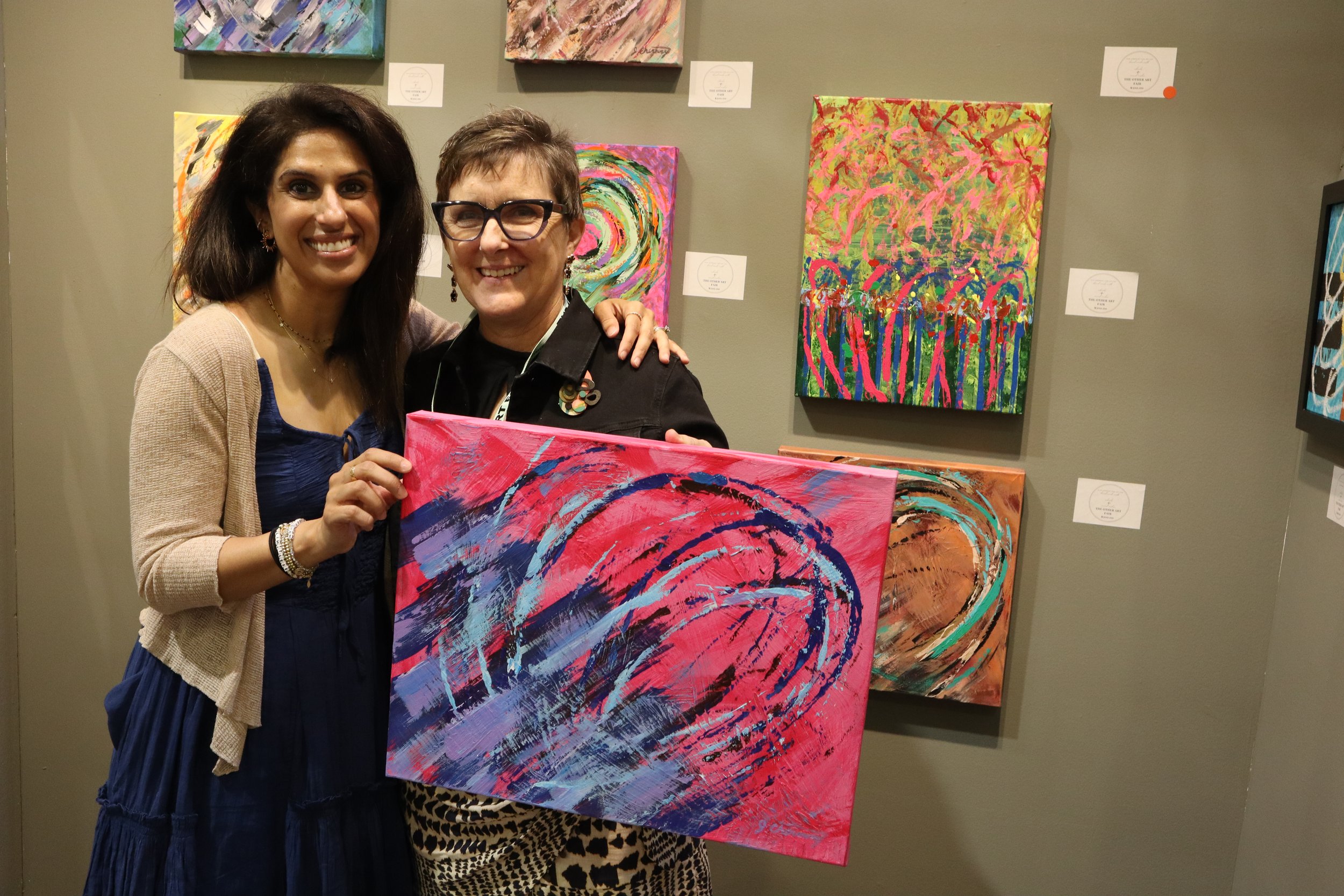 Jean Cherouny with collector with her rollerblade painting at The Other Art Fair Dallas, Texas