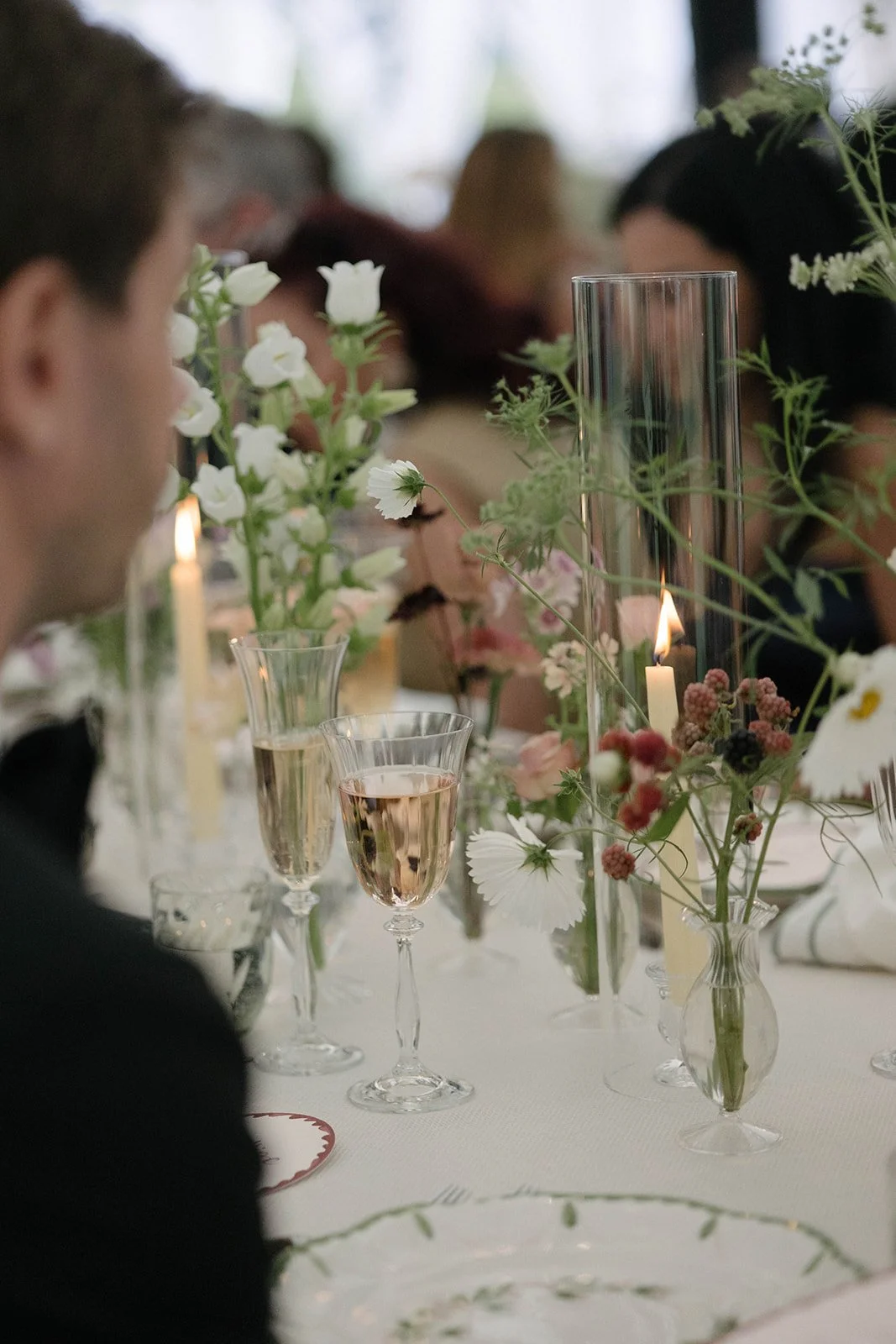 Close up of elegant Cornwell Manor wedding table with floral centrepieces champagne glasses and candles styled with luxury garden style floristry by The Botany House
