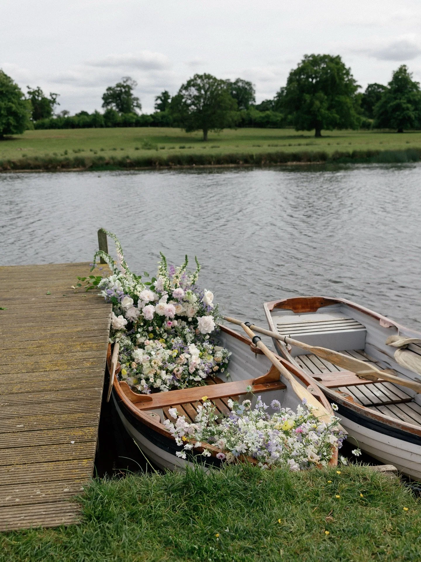 One of my favourite ways to repurpose wedding flowers was filling a little boat and rowing across the lake at Sibton park. We carefully transported table arrangements and aisle meadows across a field of sheep in my little trolley and arranged them ar