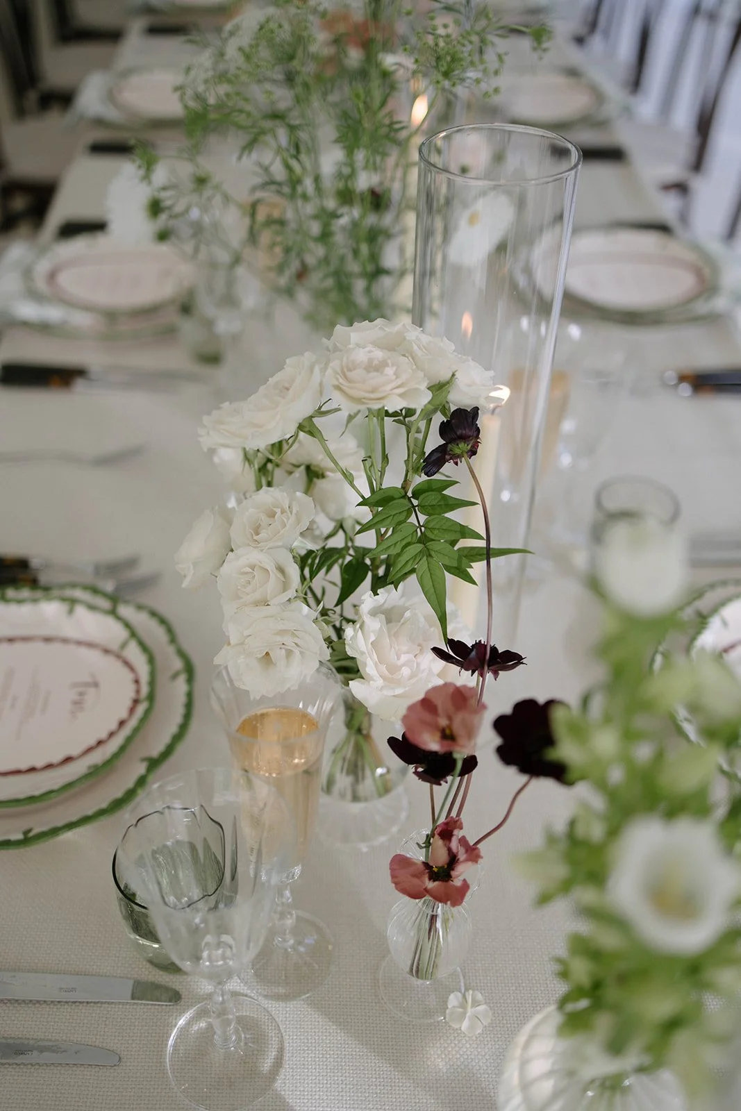 Close up of a blush and white floral centrepiece on a Cornwell Manor wedding table surrounded by glassware and place settings styled by The Botany House wedding florist