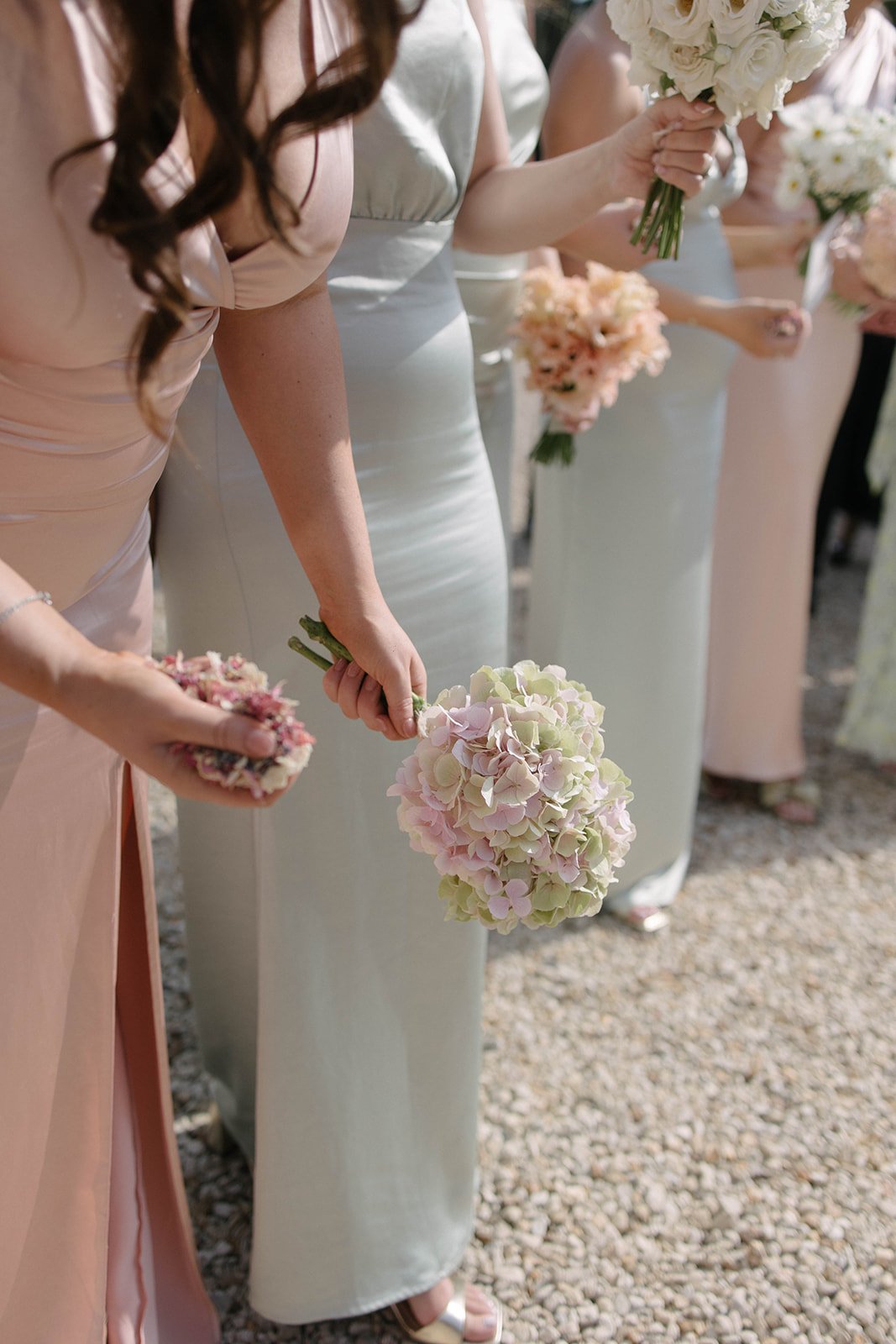 Bridesmaids in pastel dresses holding seasonal blush and cream bouquets at a Cornwell Manor wedding, styled with bespoke garden-style floristry by The Botany House in collaboration with Attabara Studio.