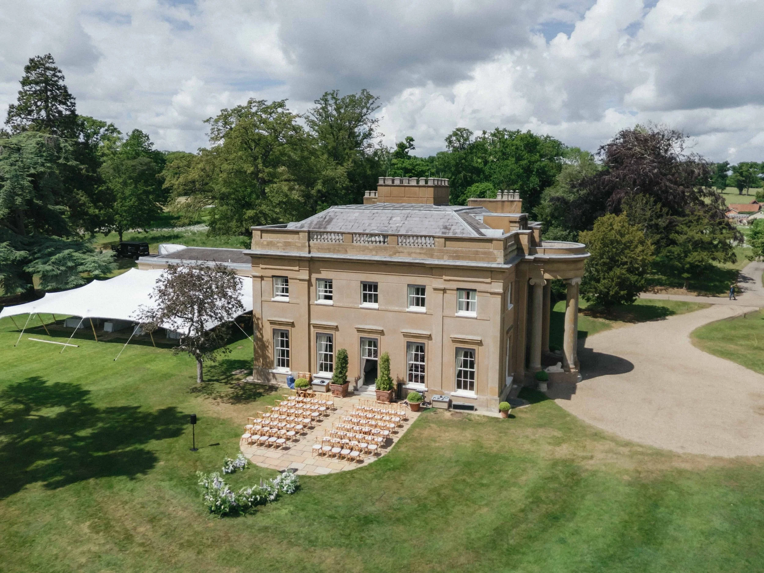 Elegant manor and outdoor wedding setup. Historic Sibton Park Estate wedding setup with floral ceremony arrangements and rows of chairs for Virginia & Ryan outdoor summer wedding florals. The Botany House florist Wilderness Reserve
