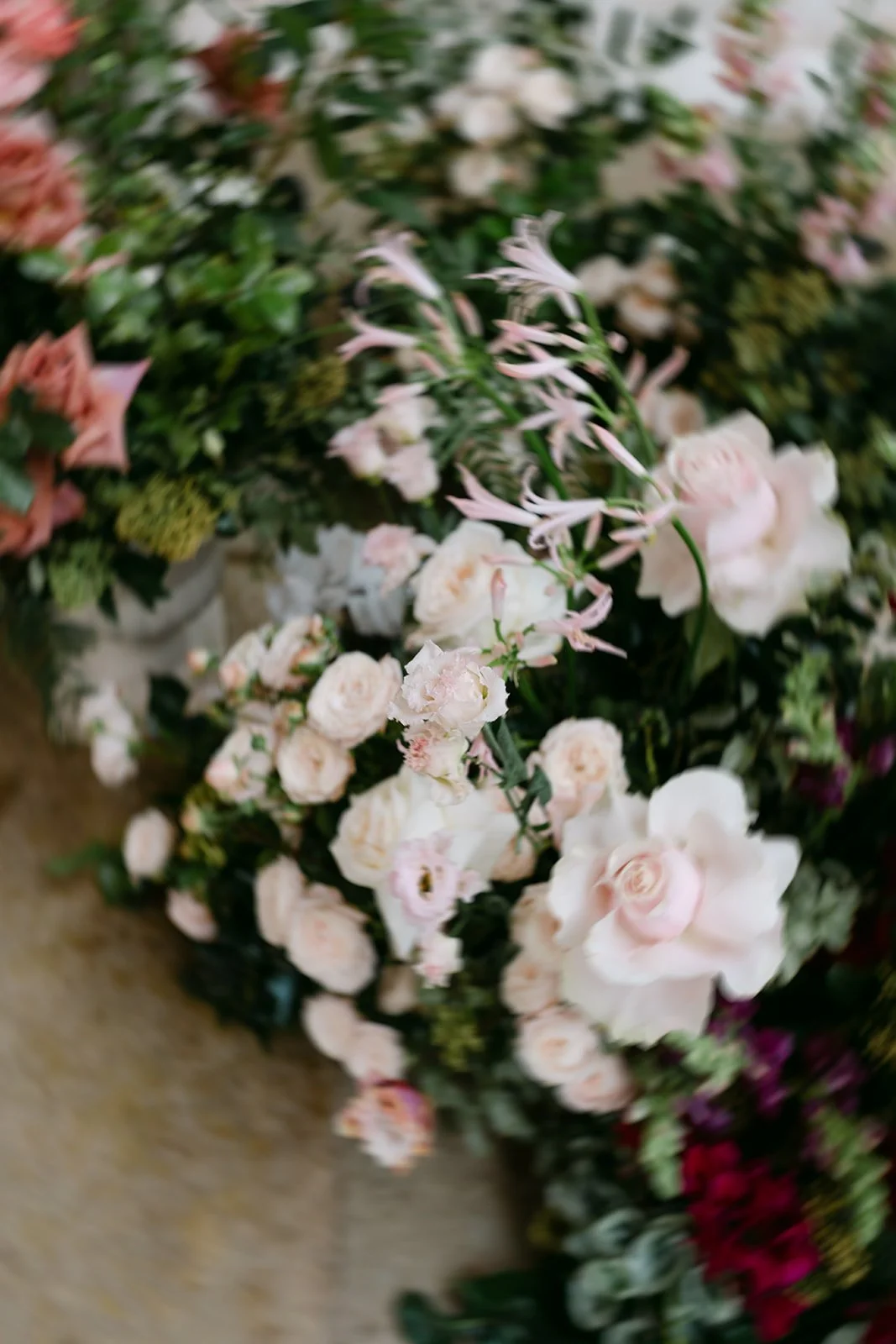 Ceremony florals in shades of pink and white with green foliage at Kin House in the Cotswolds