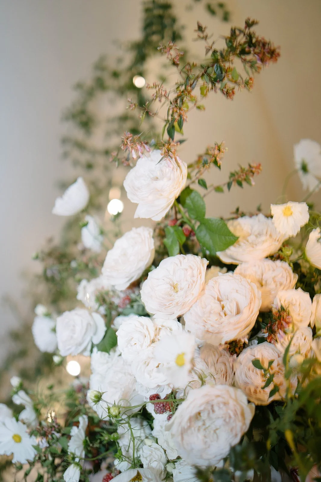 Close up of a luxury garden style floral arrangement with white roses purple blooms and berries at a Cornwell Manor wedding styled by The Botany House wedding florist