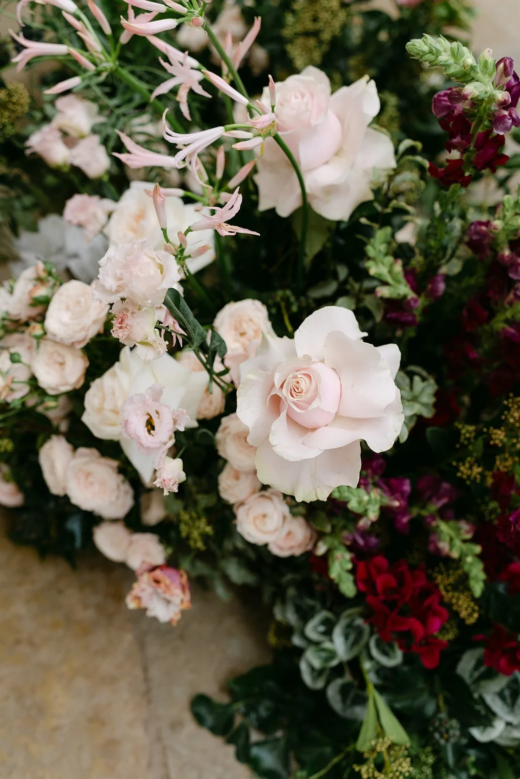 Close-up of a variety of pastel-colored flowers, including roses, lisianthus, and other blooms, arranged together. The Botany House Kin House