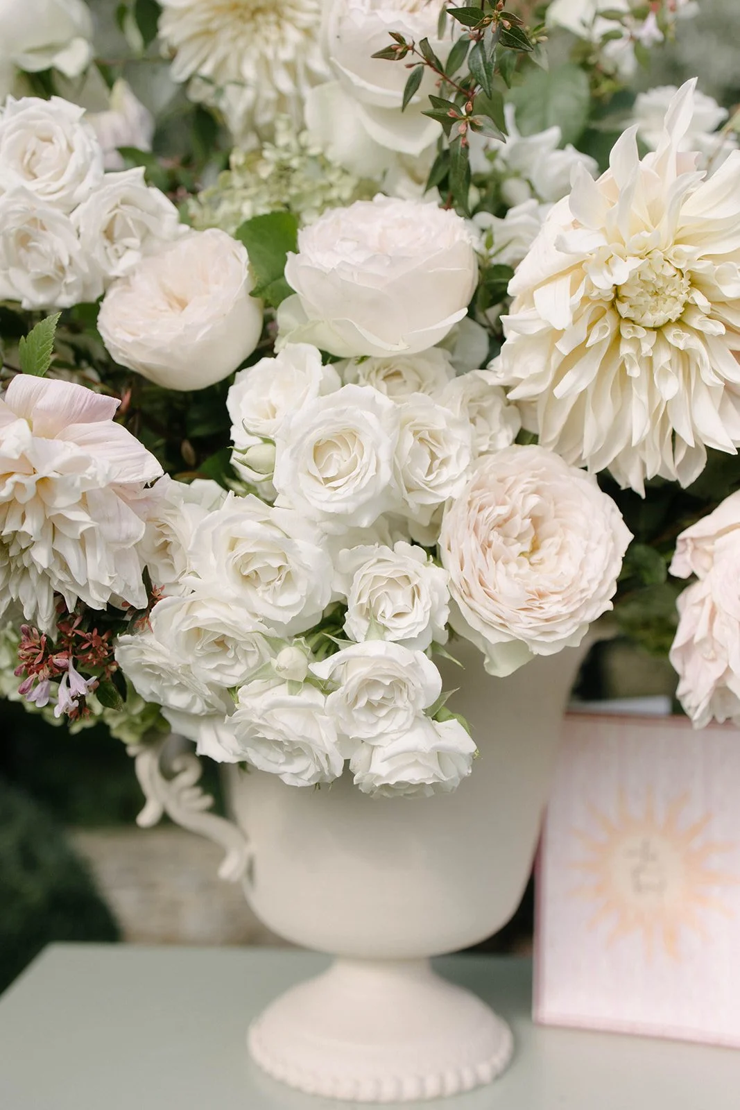 Luxury garden-style table arrangement of white roses and seasonal blooms in a vase at a Cornwell Manor wedding, styled with bespoke wedding floristry by The Botany House.