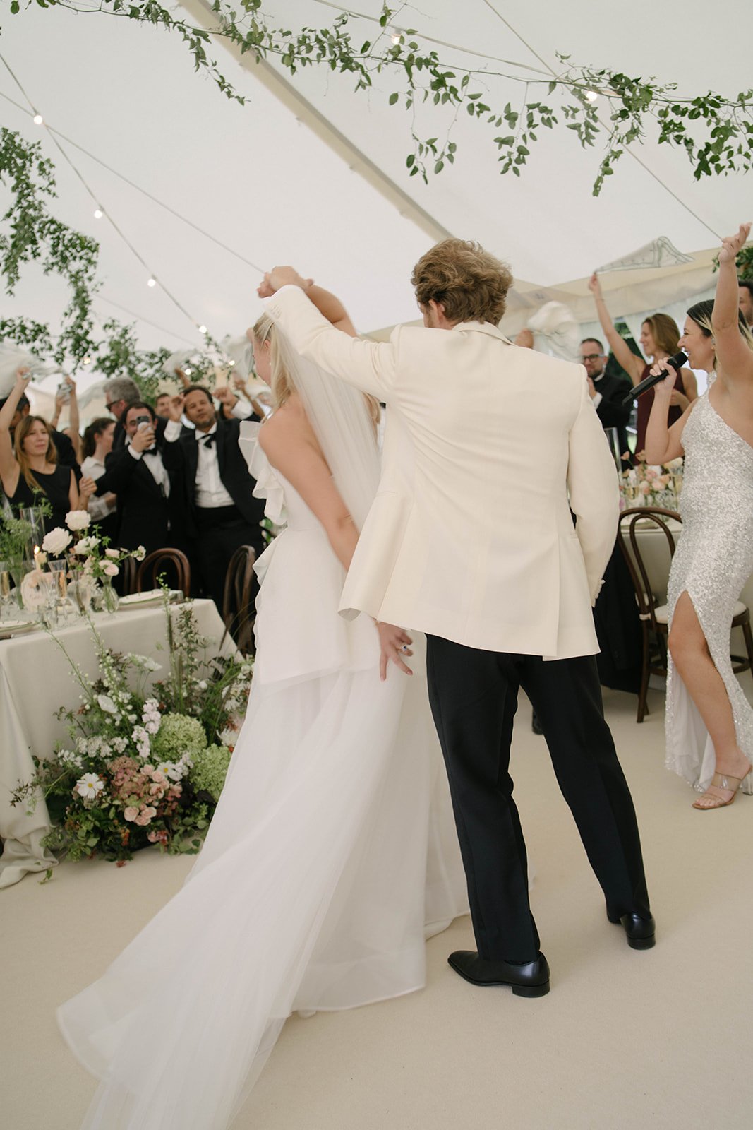 Wedding reception dancing at Cornwell Manor surrounded by guests and floral installations styled with bespoke luxury wedding floristry by The Botany House