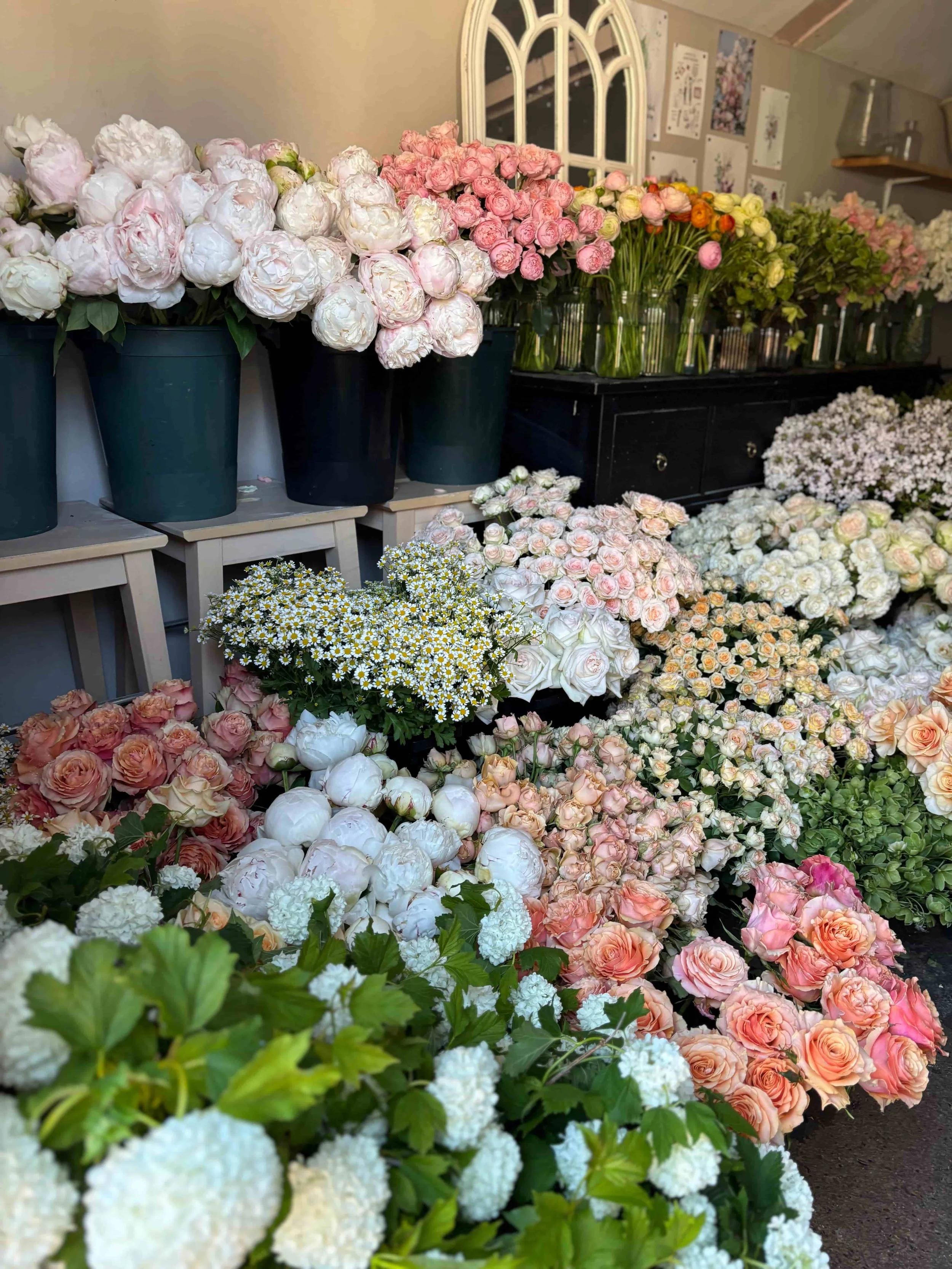 Display of various colorful flowers including roses, peonies, and daisies in pots and vases in The Botany House studio in Norfolk. In preparation for Mother's Day bouquet gifting, the best in Norfolk