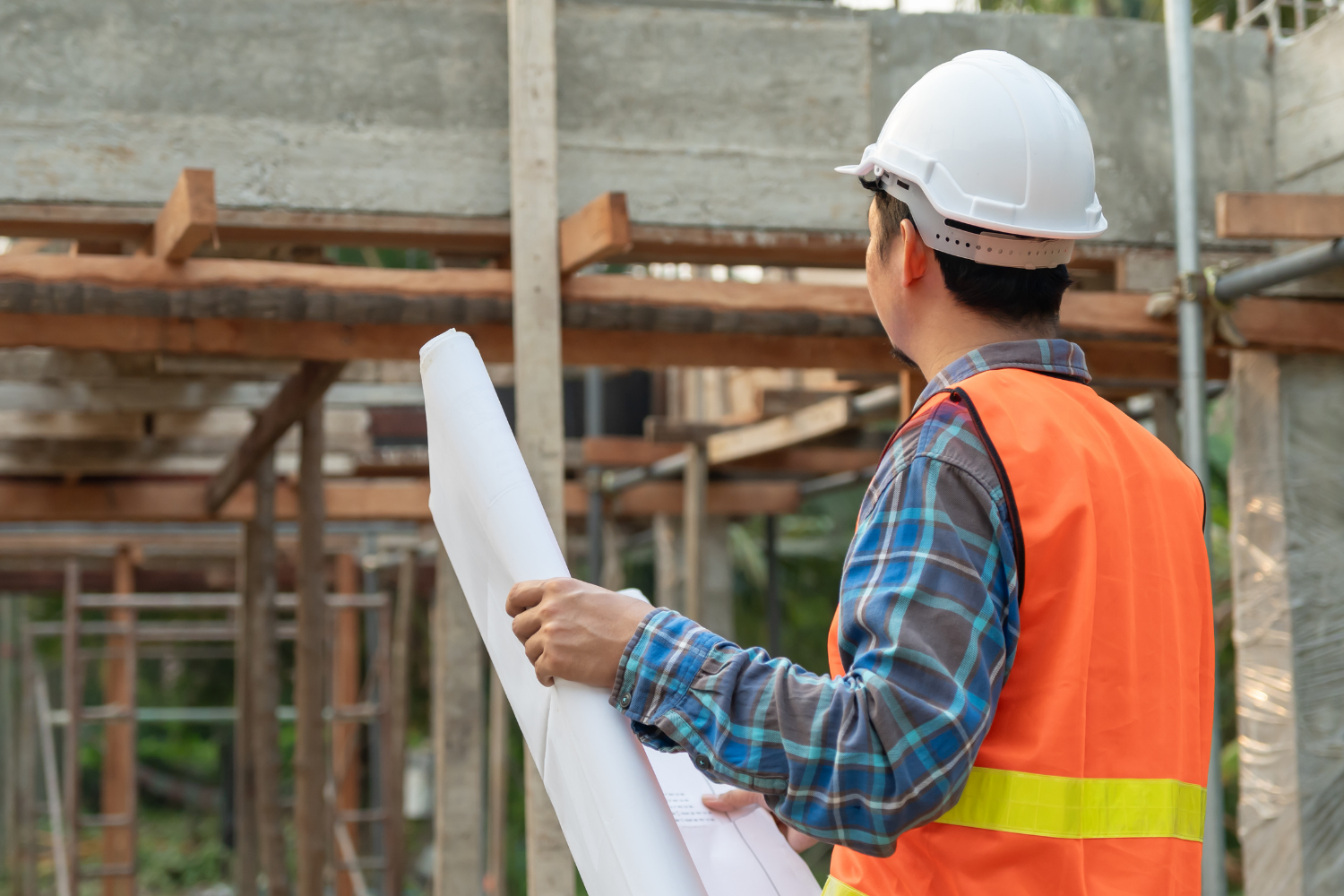 Builder reviewing construction plans on site during the early stages of a custom home build in Sydney