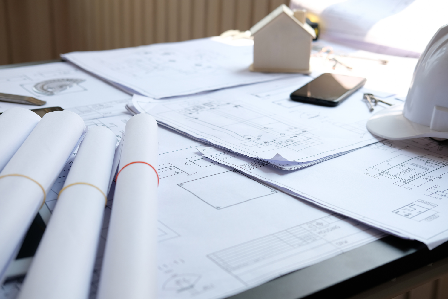 Construction plans and documents on a desk representing transparency and planning in a building project