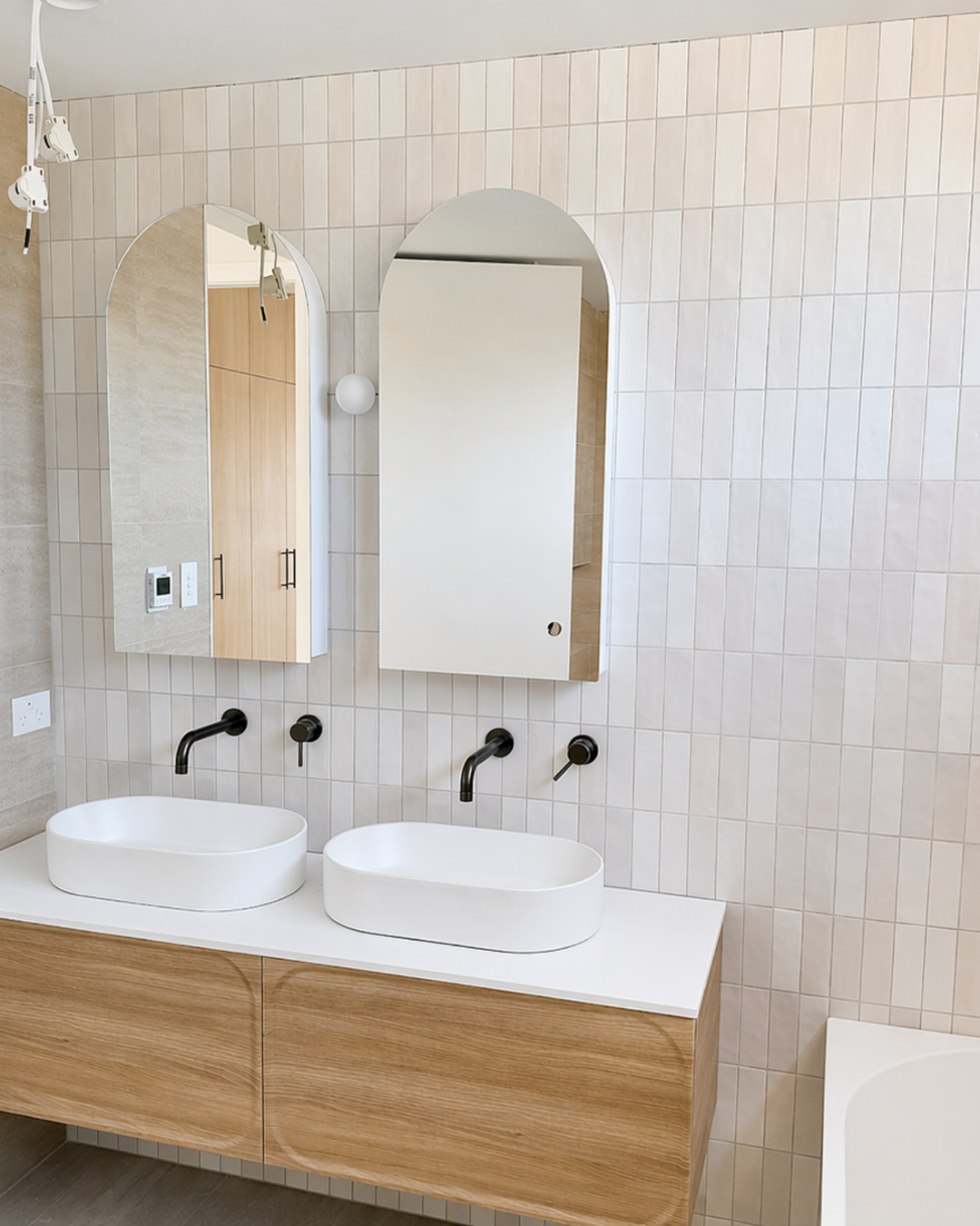 Bathroom vanity in a Haymet Street duplex with double basins, arched mirrors, and tiled wall finishes nearing completion