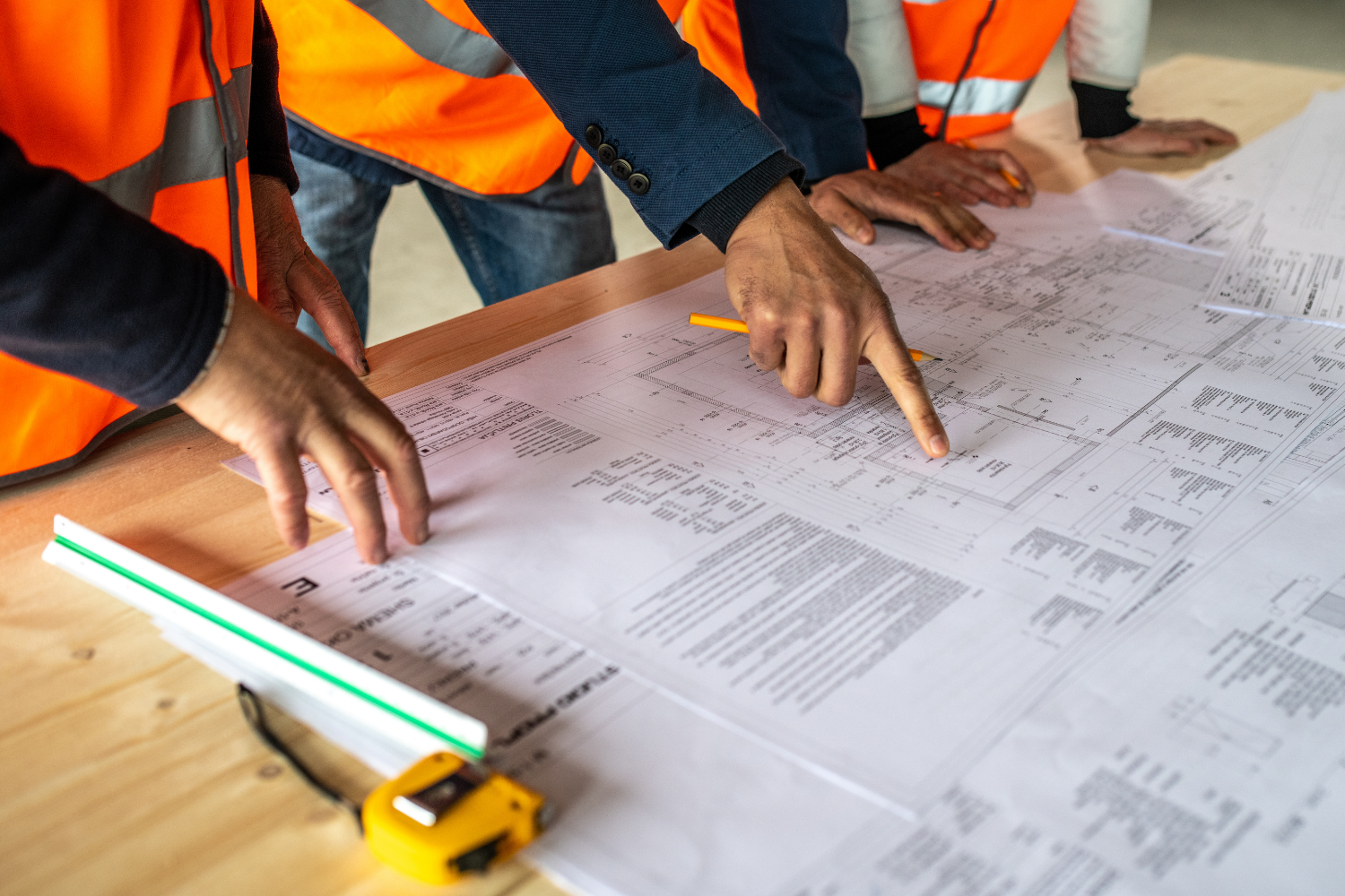 Construction team reviewing detailed building plans to manage costs and avoid budget blowouts