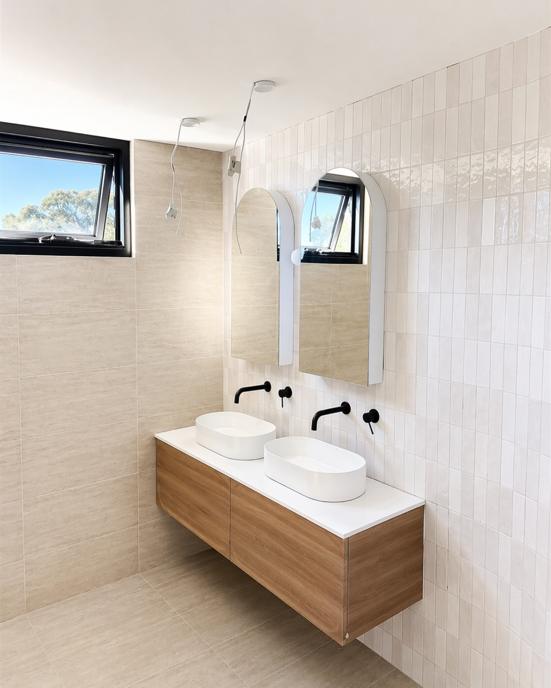 Bathroom vanity in a Haymet Street duplex with double basins, arched mirrors, and tiled wall finishes nearing completion