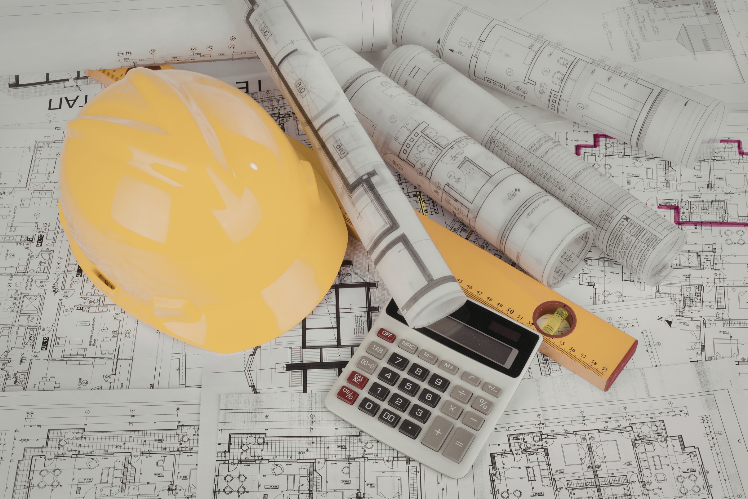 Construction plans, hard hat, and calculator representing project planning and timelines