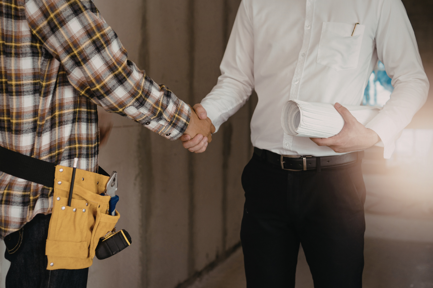 Builder and client handshake representing trust and clear communication during a home build