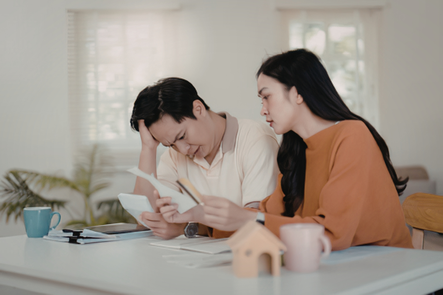 Homeowners reviewing documents and costs, showing uncertainty and concerns during the building process