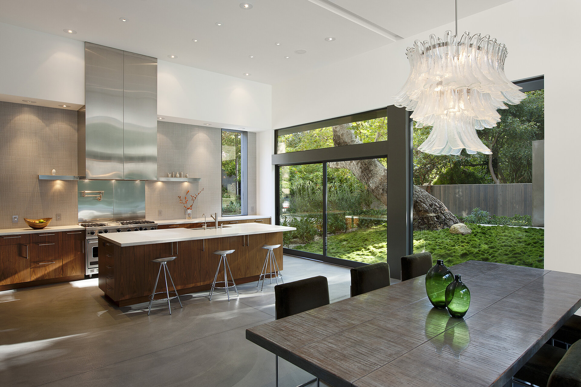 Top best luxury general contracting company modern home in a canyon neighborhood of Los Angeles featuring iconic design by architect Chu and Gooding featuring mid century style kitchen with stainless steel and wood cabinets and concrete floor.  