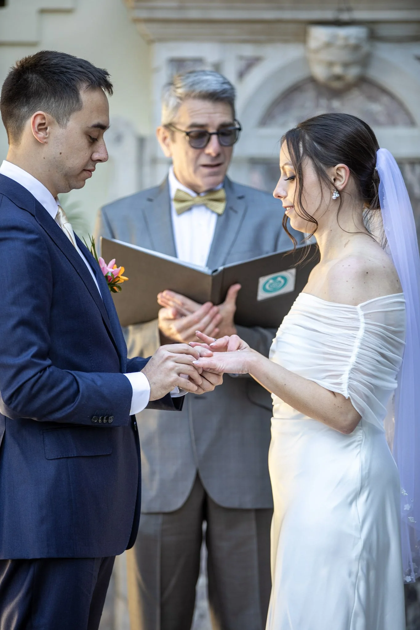 man and woman exchanging rings in front of wedding officiant at The Bonnet House in Fort Lauderdale.