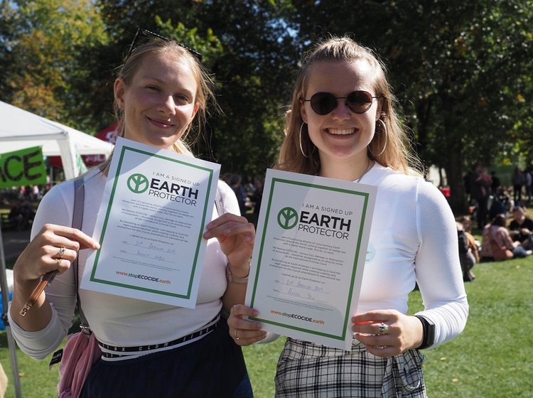 Dos chicas mostrando sus certificados como Protectoras de la Tierra