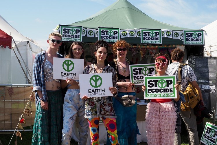 jóvenes con pancartas de la campaña en un puesto en un festival de verano
