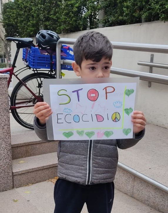 niño sujetando cartel hecho por él en apoyo a la campaña durante la Semana por el Reconocimiento del Ecocidio