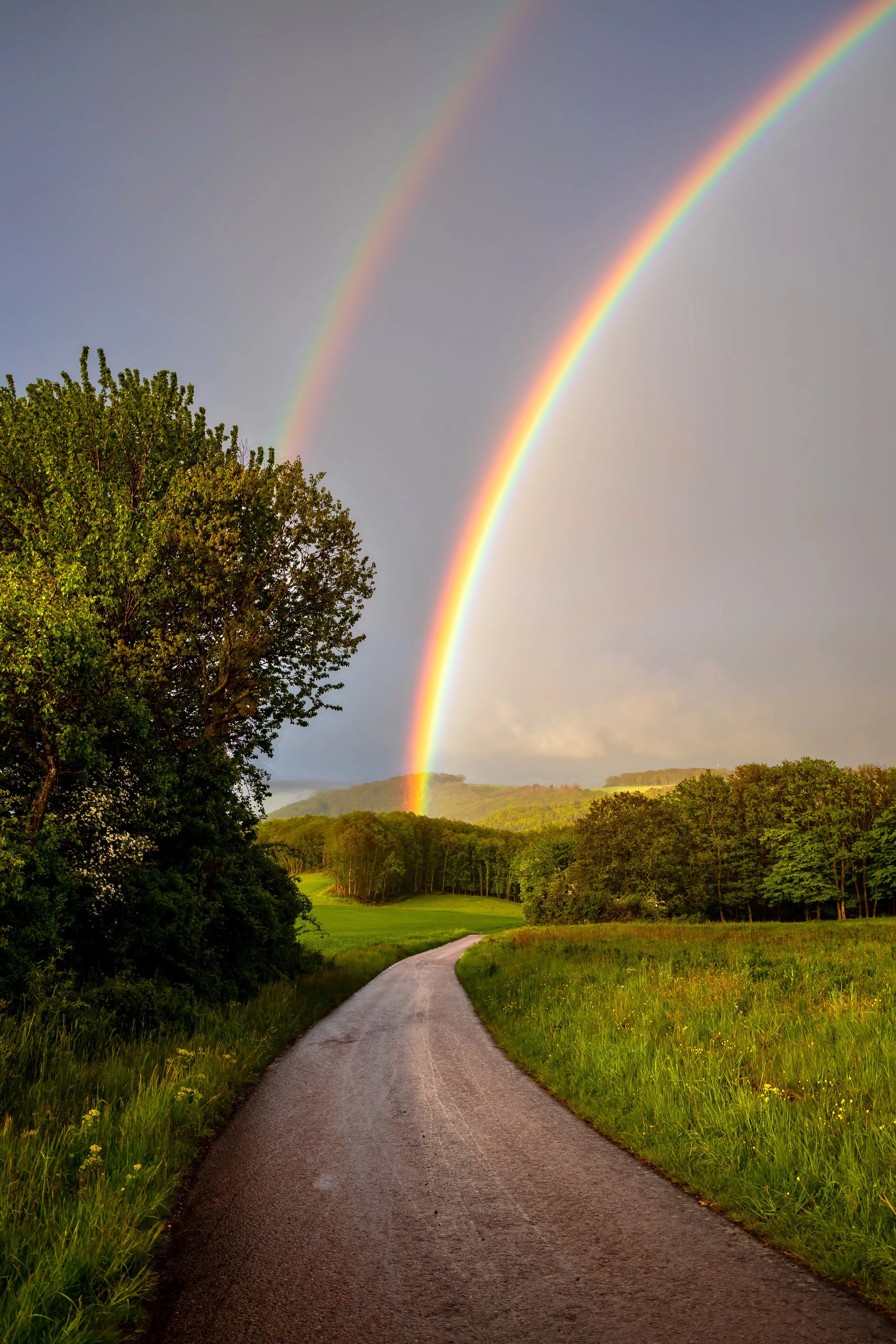 Rainbow at the end of a road signaling hope