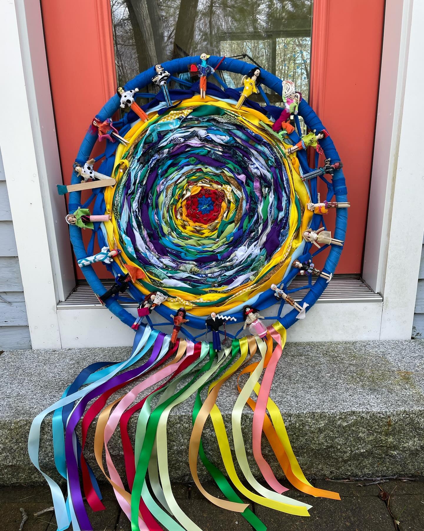 Mandala community weaving 
➰ 
woven by first and second graders in New Hampshire. 
🖐🏼🤚🏾🖐️
The colors reflect the temperature of the day. It was added onto continually for months. 
⭐️
Then students made the clothes pin people dressed according to