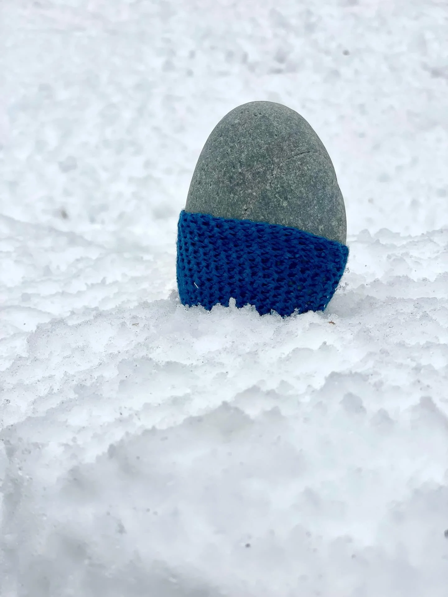 First snow. 
❄️❄️❄️❄️ 
❄️❄️❄️❄️
It muffles sounds, 
blankets the gray bare branches 
And cushions my footsteps. 
❄️❄️❄️❄️
and makes a lovely resting place for this Stone cozy.

This indigo dyed stone cozy will stay out this winter. See you in the spr