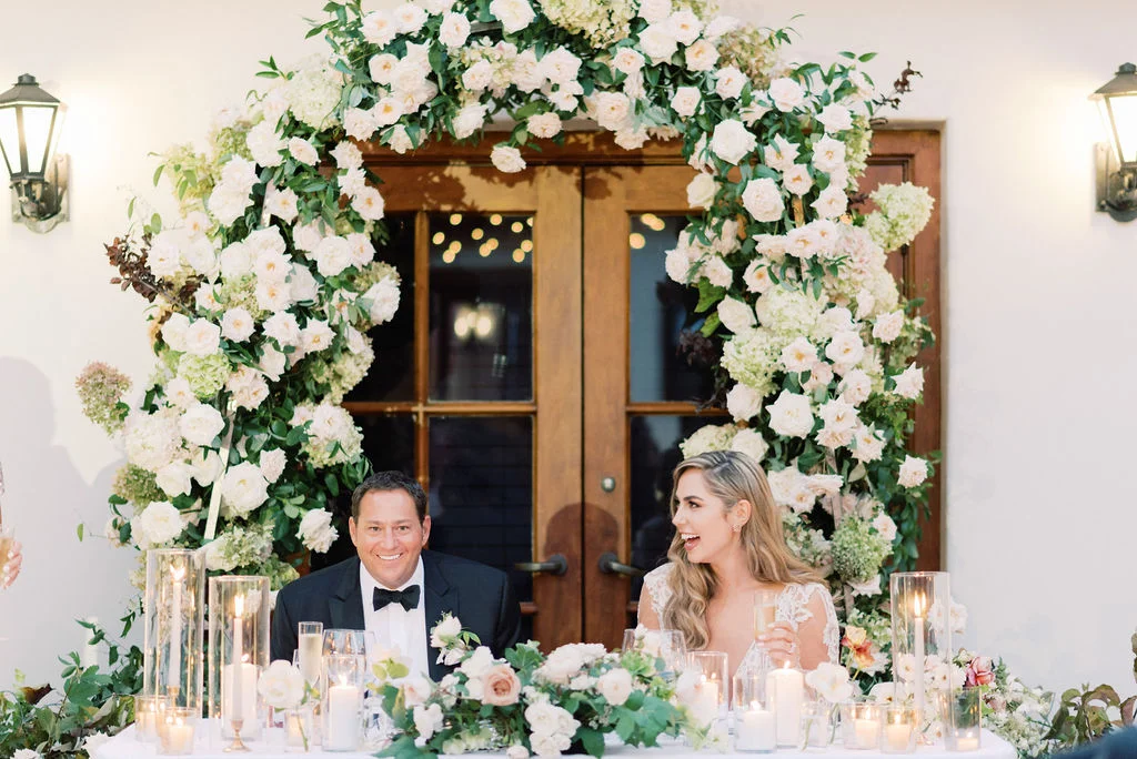 aboutdetailsdetails.com | Jana Williams | Santa Barbara Wedding | Ritz Carlton Bacara | Outdoors Wedding | Outdoors Reception | Table Setting | Candles | White Florals | Blush | Bride | Groom | Floral Arch