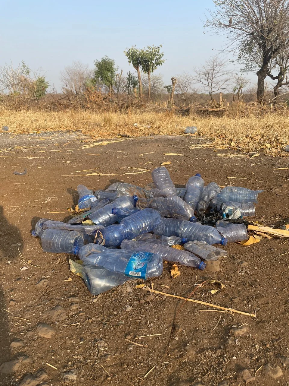 With no trash pick-up, plastic trash gets set aside at the perimeter of these villages.
