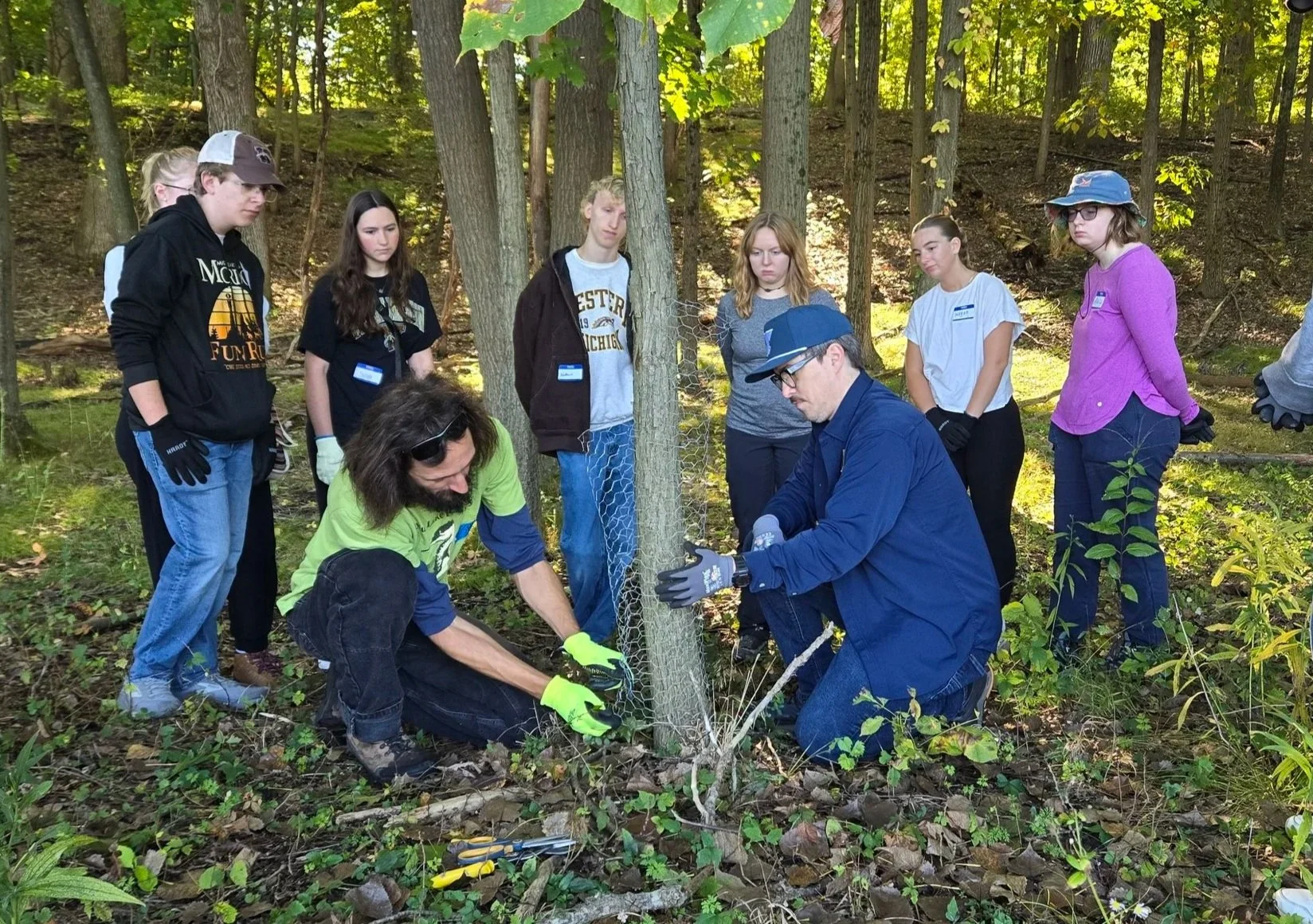  President Josh Kieser (left) and board member Tom Howes (right) demonstrate how to add a mending strip of chicken wire to expand a tree cage. 