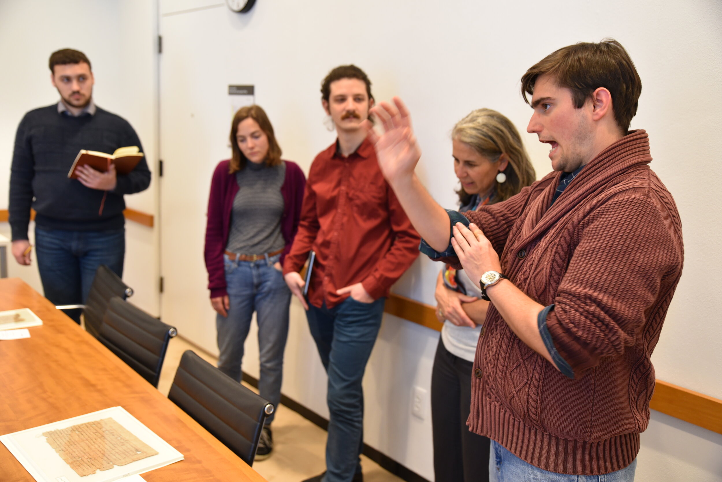  Graduate student Joseph Morgan explains how he examines a papyrus text to the rest of the Yale team. 