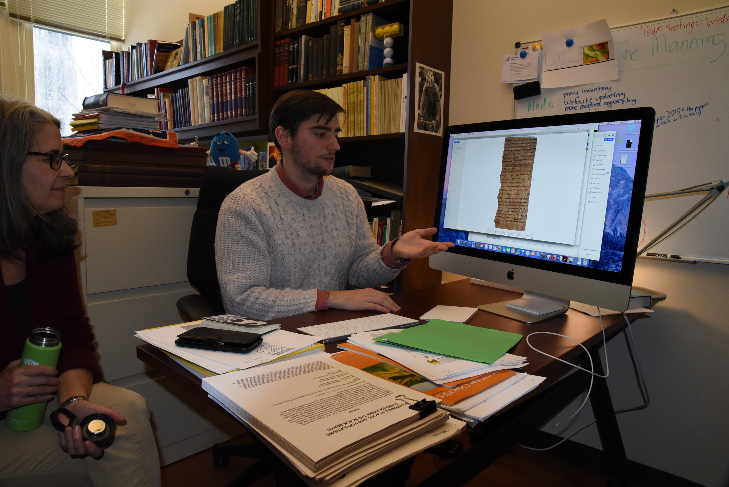  Joe Morgan describes a papyrus text to other members of the Yale team. 