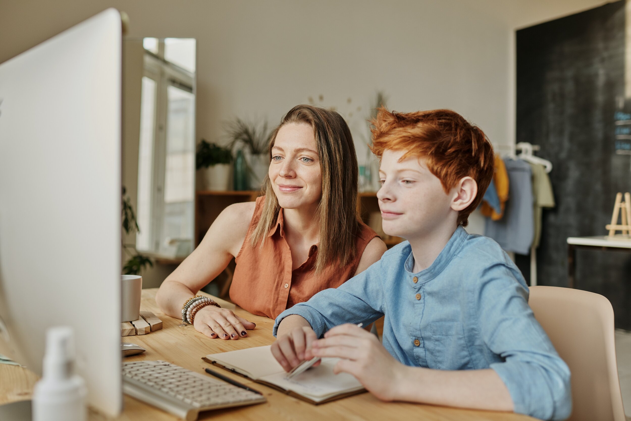 photo-of-woman-and-boy-smiling-while-watching-through-imac-4145350.jpg