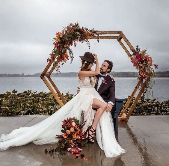 05-a-bright-fall-hexagon-wedding-arch-with-dried-leaves-in-burgundy-and-rust-greenery-and-blooms.jpg