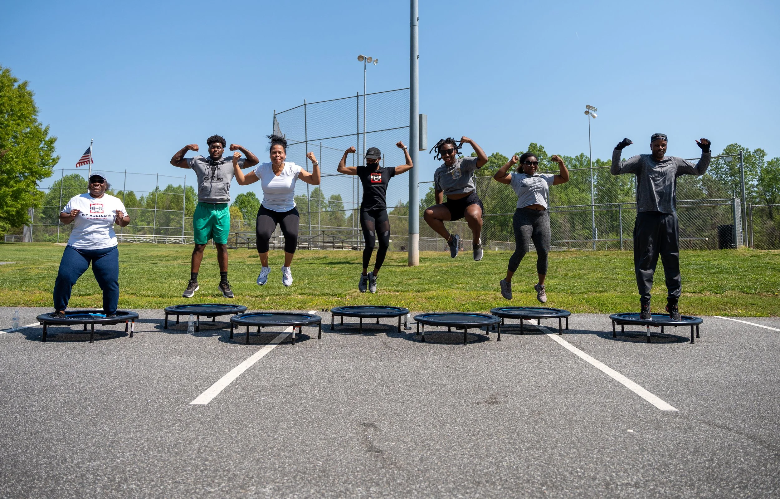 MJ Fit Training participants exercising on mini trampolines during an outdoor group fitness workout.