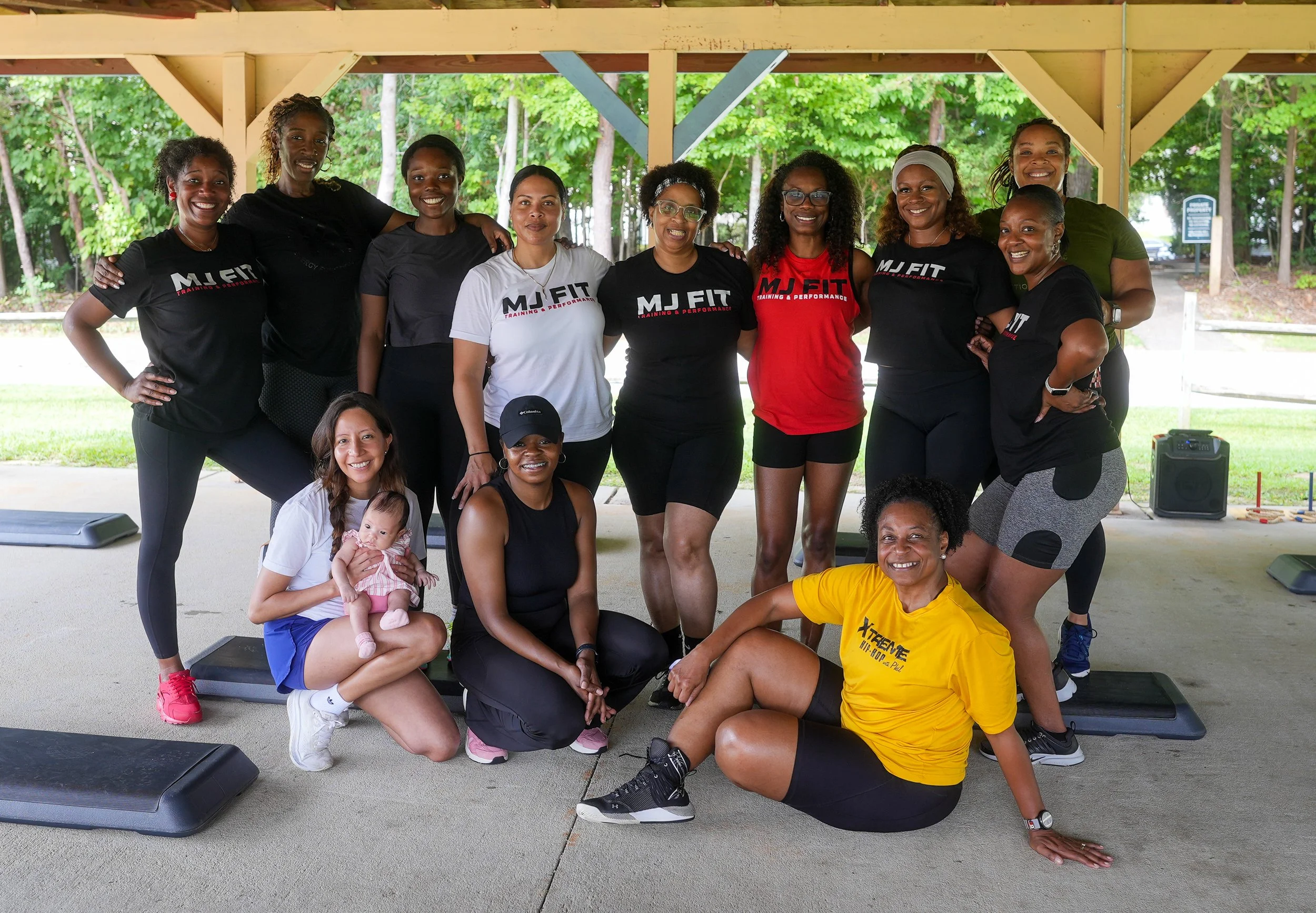 MJ Fit Training community posing together after an outdoor group fitness event.