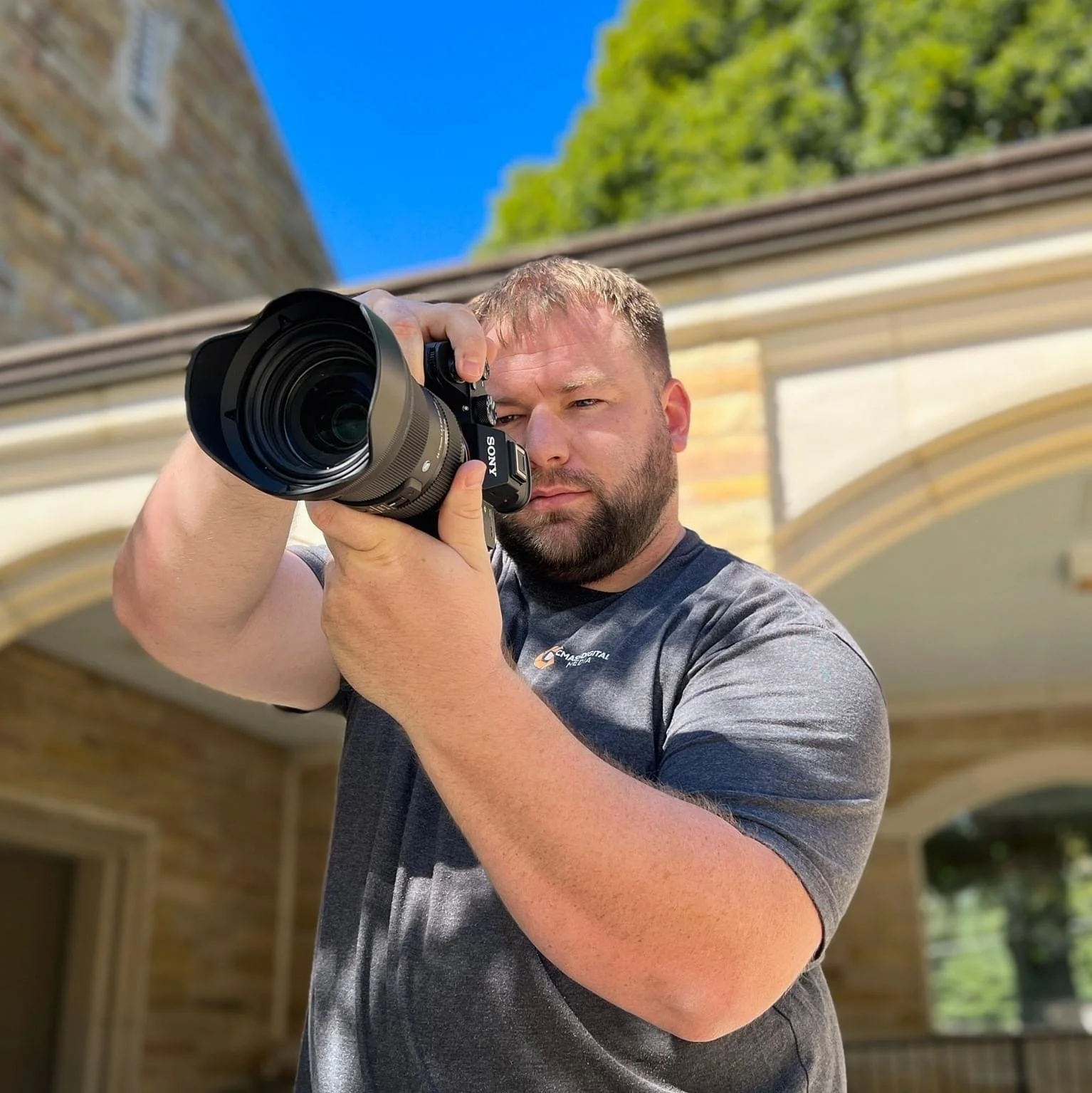 Photographer Chris Massey working behind the camera during an outdoor photo shoot.