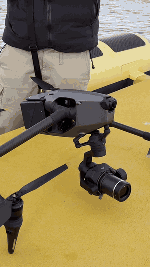DJI Inspire 3 raising its landing gear on a boat deck, close-up of the Zenmuse X9 camera