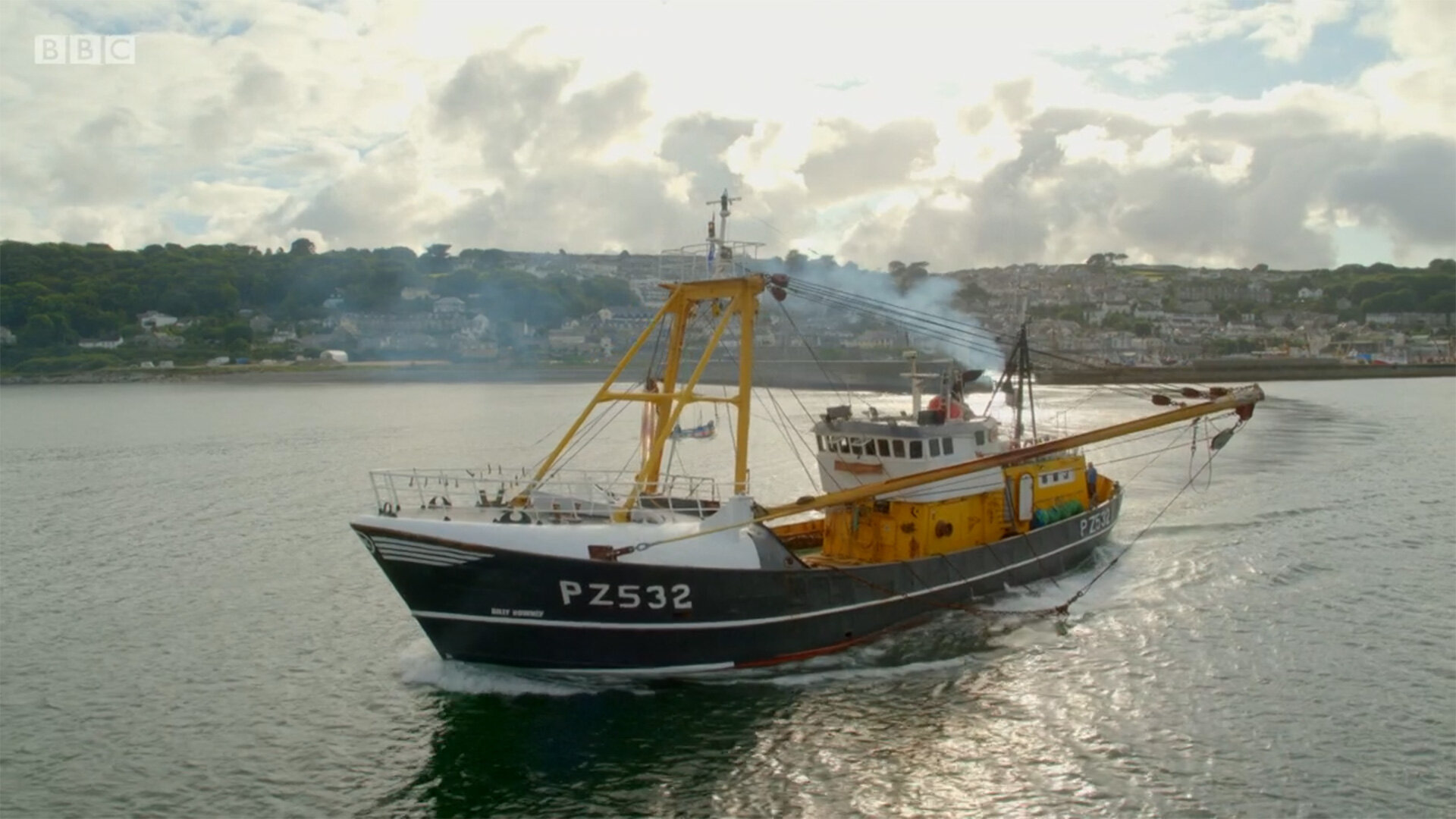Drone aerial of a Cornish fishing trawler leaving harbour, filmed for BBC Two's This Fishing Life