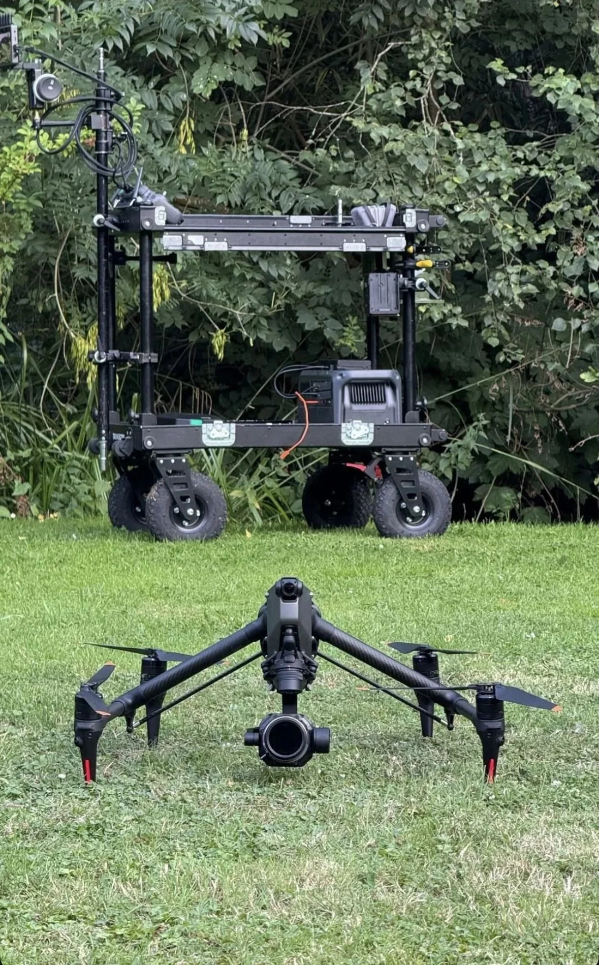 DJI Inspire 3 in front of a heavy lift cinema drone on its transport cart