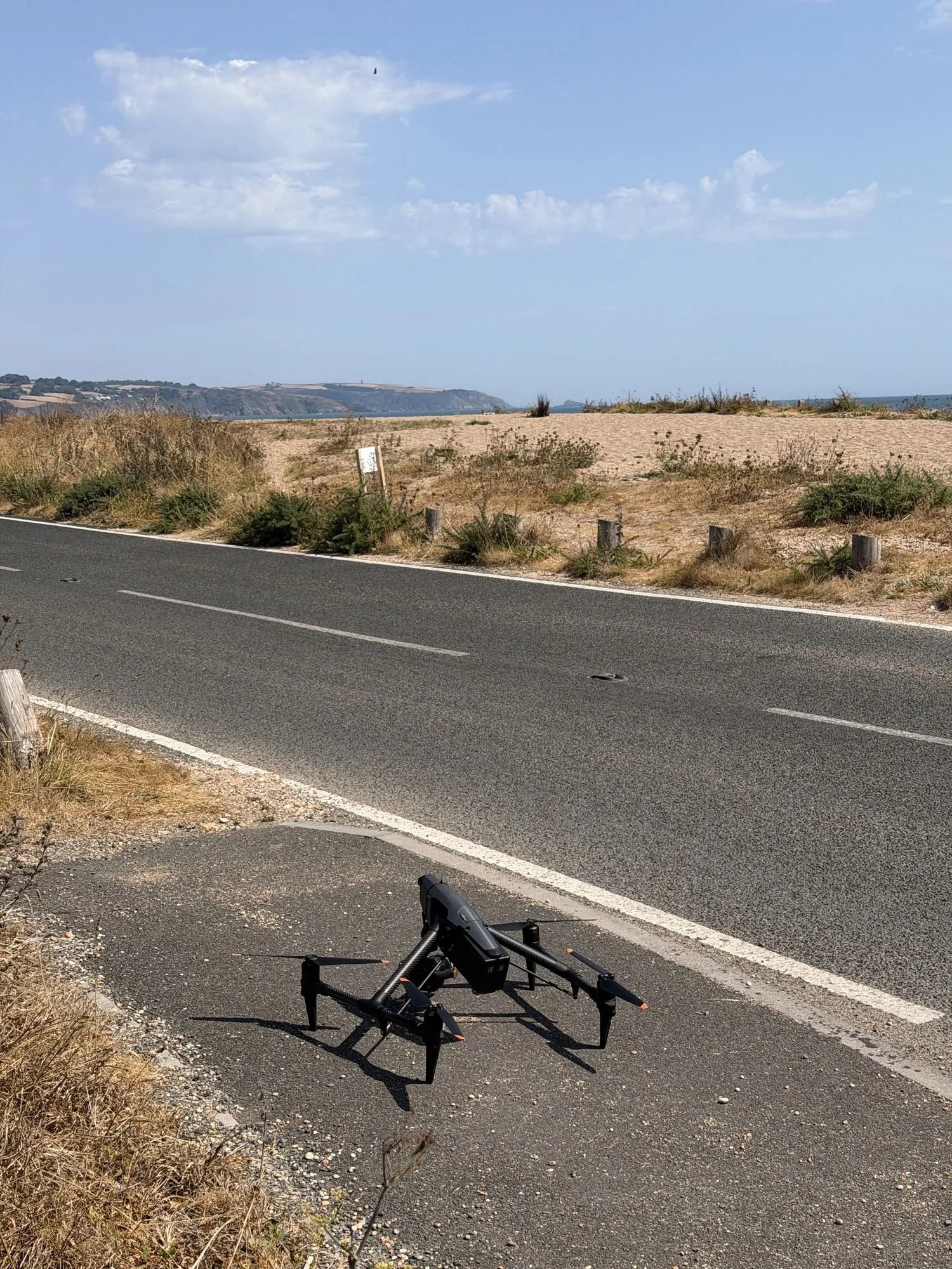DJI Inspire 3 landed beside a coast road, ready for a car shoot