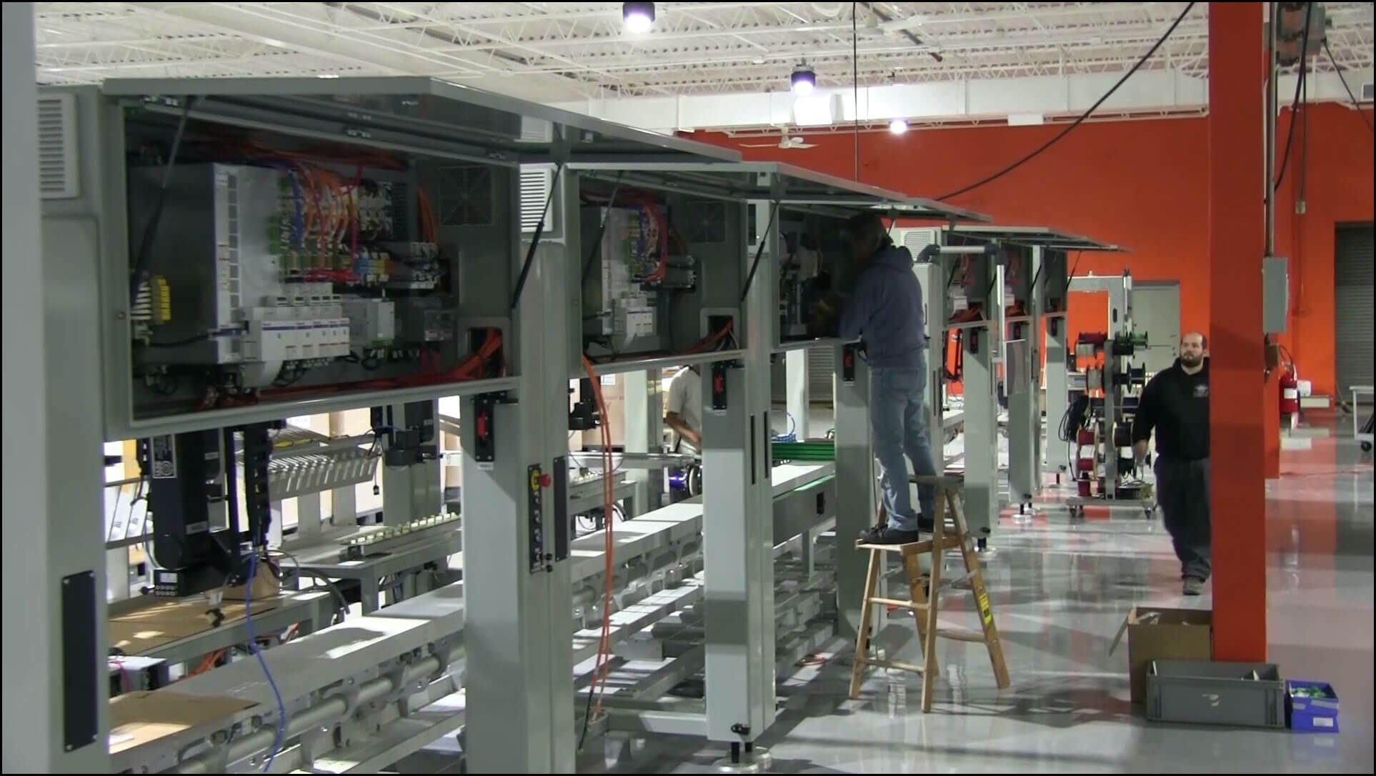 Men working on the modular frame control panel at IASE