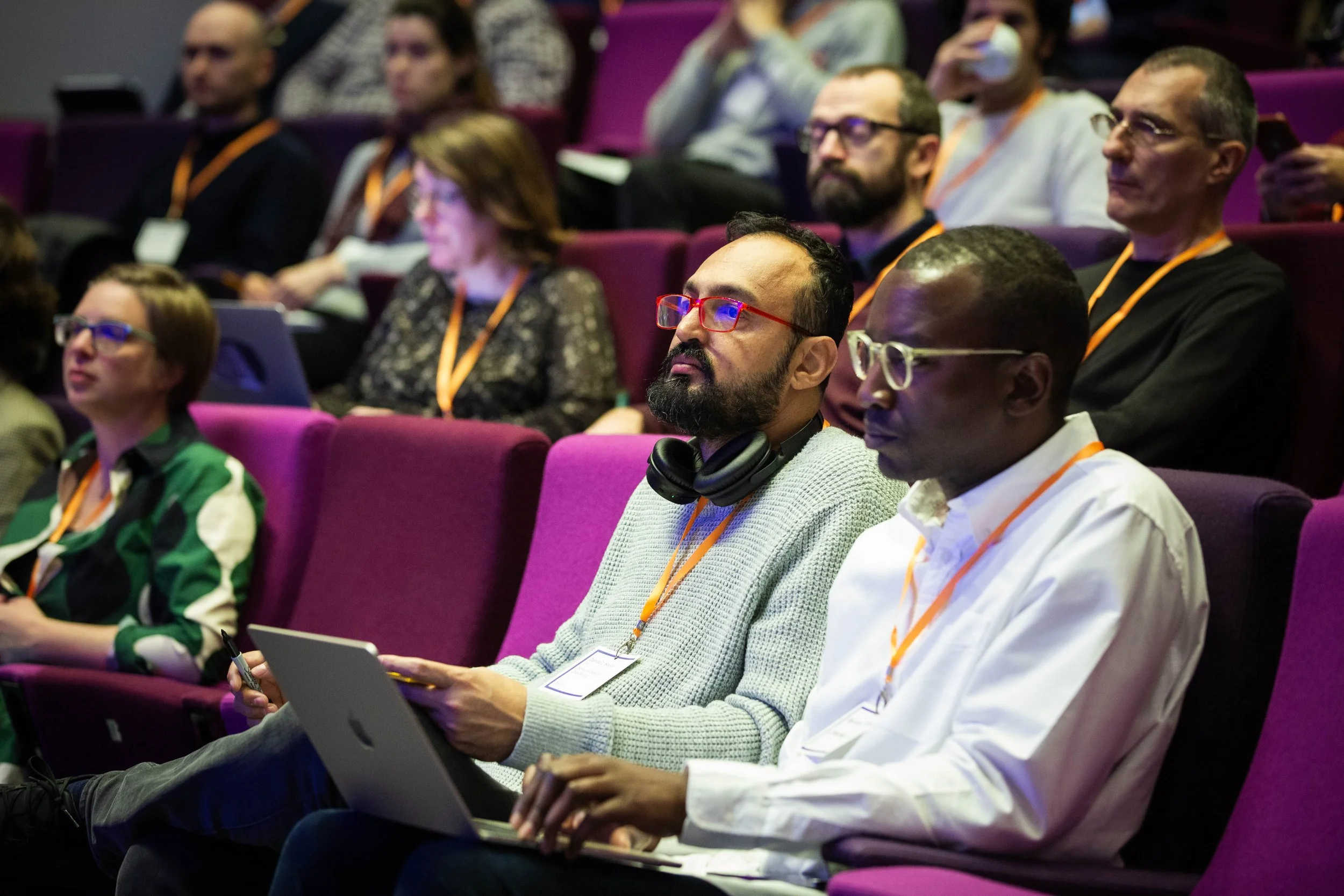 A photo of an audience sitting in an auditorium at the AI and Society Forum.