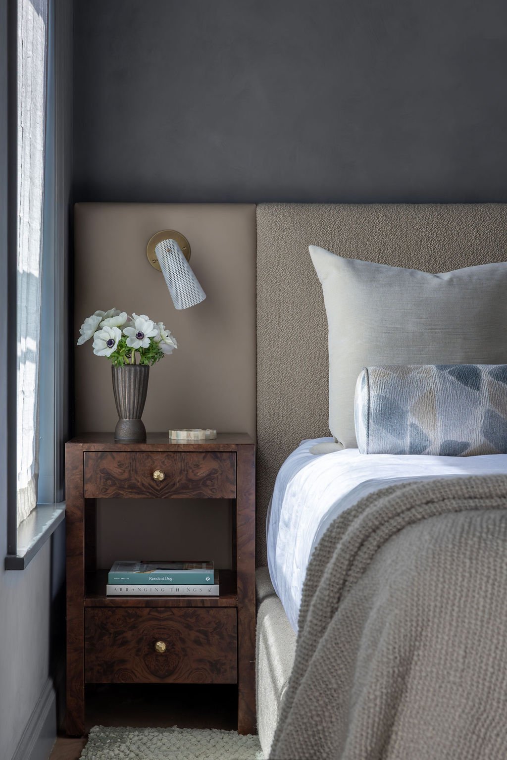 Primary bedroom with charcoal walls and upholstered bed