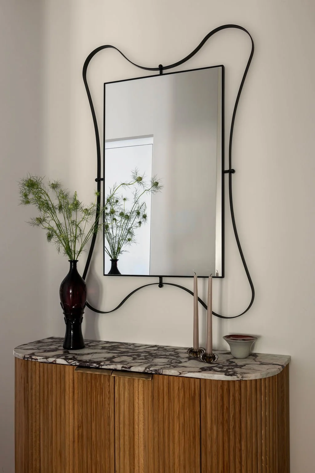 Wavy mirror on curved walnut dresser