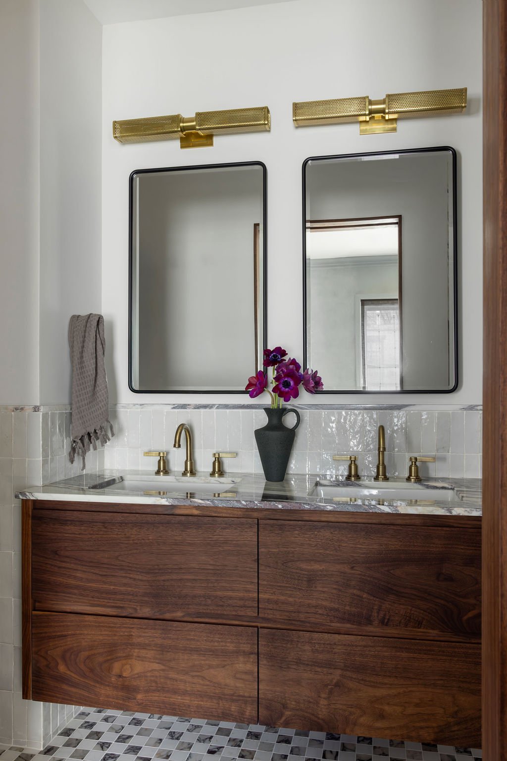 Double vanity bathroom with brass sconces