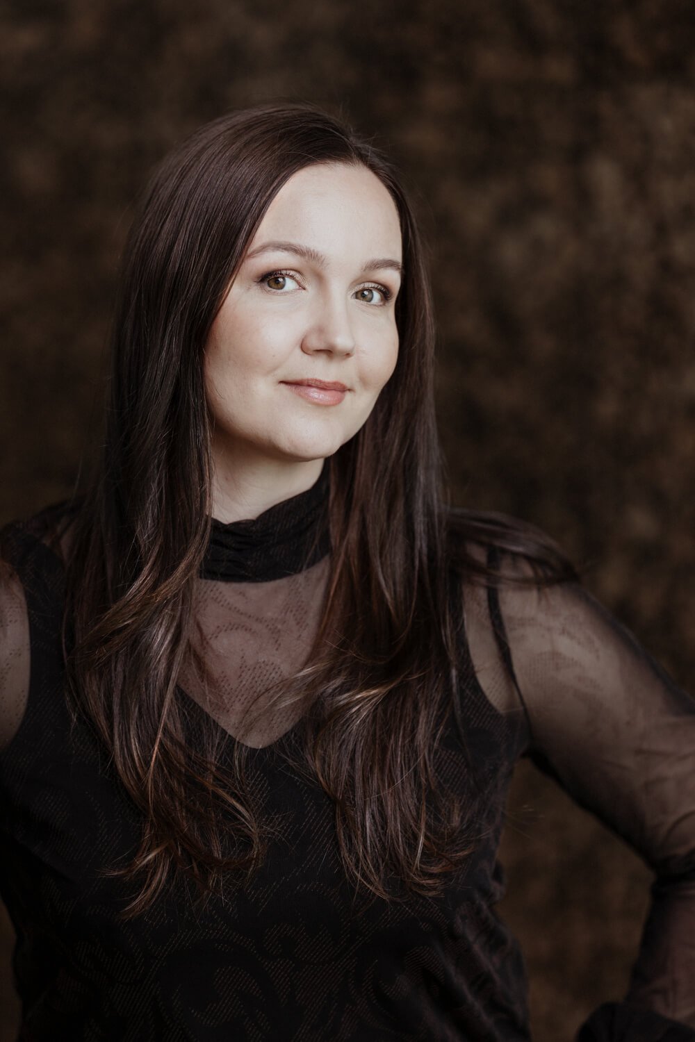 Nainen graniittiseinän edessä mustissa vaatteissa