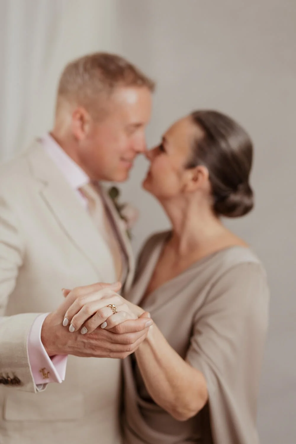 Studiohääkuva jossa sormus näkyy ja pari katsoo toisiaan